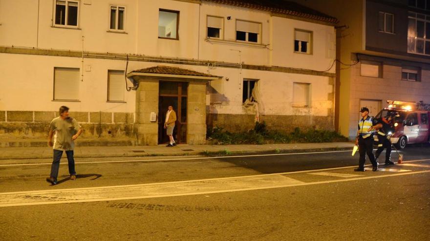 El propietario (izquierda) abandona la vivienda (al fondo)  dañada por la explosión de butano. //Gonzalo Núñez