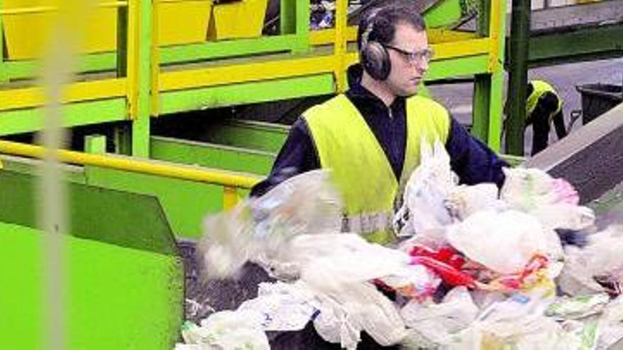 Un trabajador de Cogersa separa los plásticos en una de las cadenas de reciclaje de la planta.