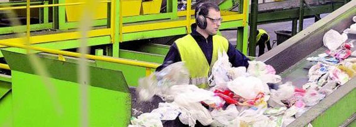 Un trabajador de Cogersa separa los plásticos en una de las cadenas de reciclaje de la planta.