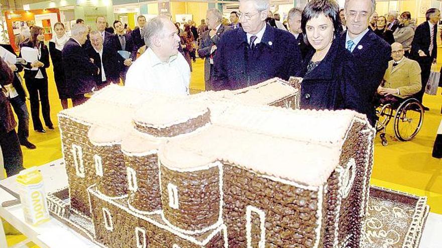 Touriño, Suárez Canal y la alcaldesa de Silleda contemplan una reproducción de Carboeiro hecha con chocolate.