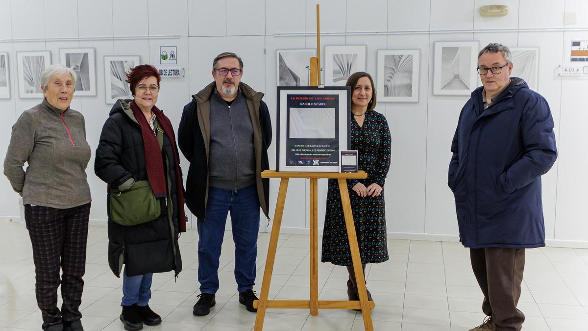 Karolo Suárez, en el centro de la imagen, junto a asistentes a la inauguración de la exposición.