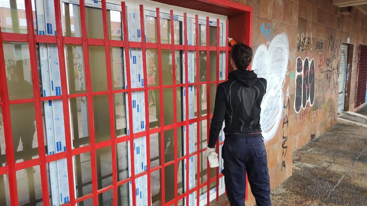 Un operario cambia una de las ventanas del centro de Alucinos en San Fermín, Usera.