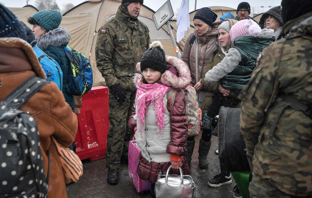 Los refugiados recién llegados buscan ayuda de los soldados del ejército polaco después de cruzar la frontera de Ucrania a Polonia en el cruce fronterizo de Medyka, en el este de Polonia, el 9 de marzo de 2022.