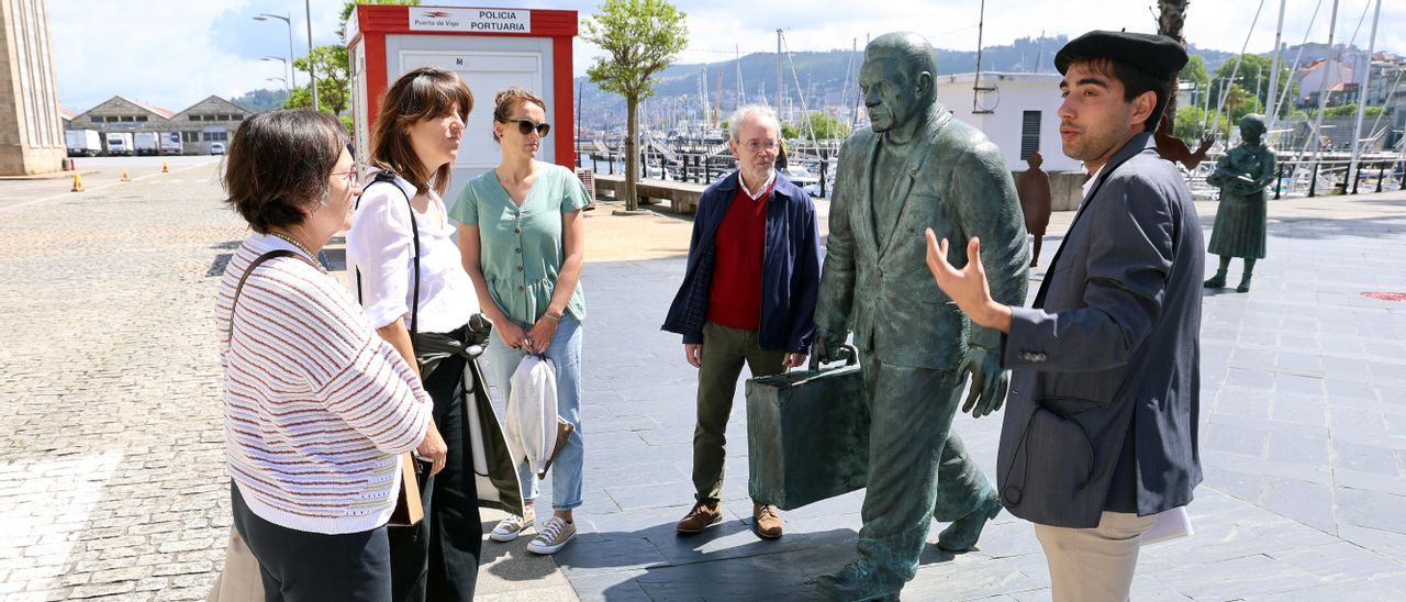 Participantes y guía de la ruta, ayer, junto a la escultura del emigrante en el Náutico.