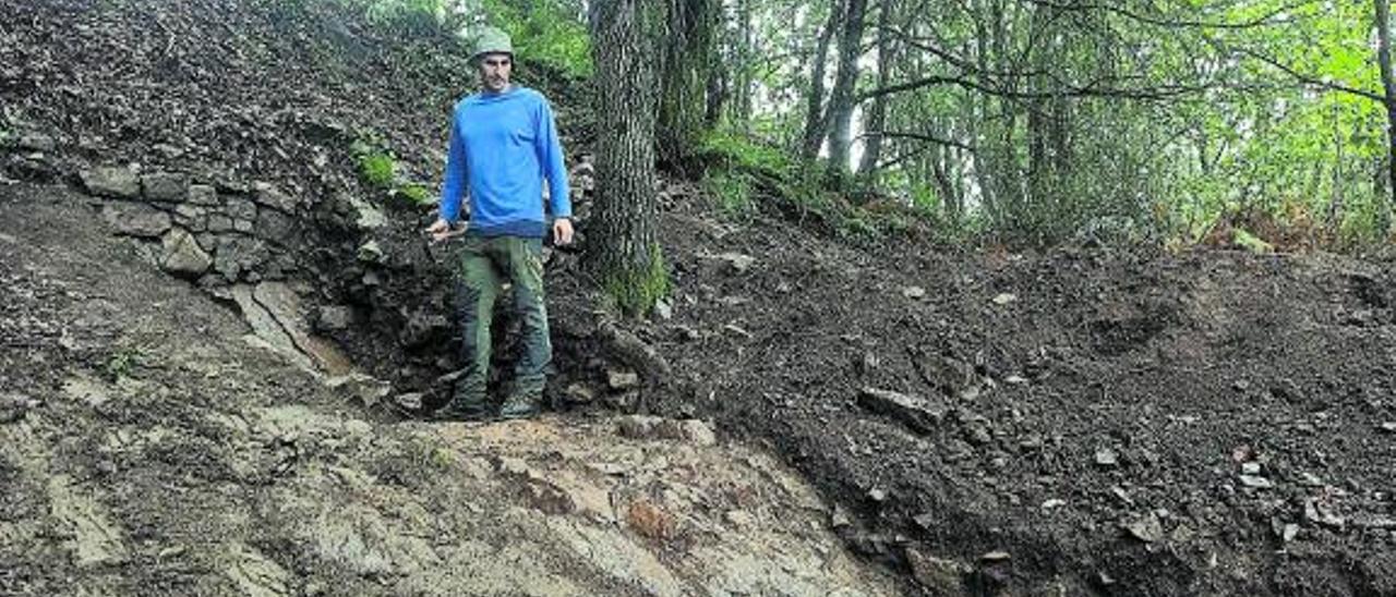 El arqueólogo José Antonio Fanjul, en una de las zonas donde el muro perimetral del yacimiento está a la vista. | S. A.