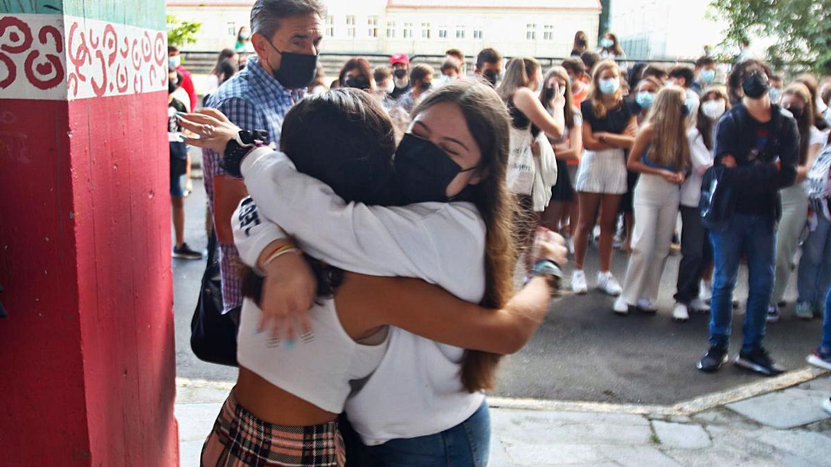 Dos compañeras se alegran de ir juntas en la misma clase.