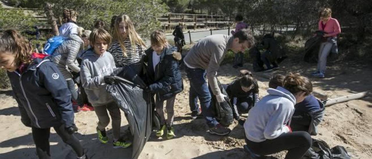 Los voluntarios retiran los residuos inorgánicos del entorno de la playa de El Rebollo.