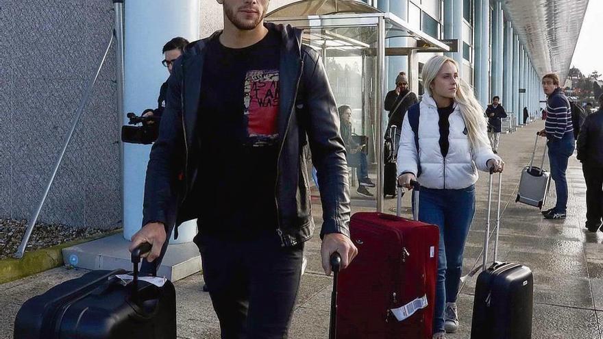 Lucas Boyé y su pareja, ayer, al abandonar el aeropuerto de Peinador. // RCCelta