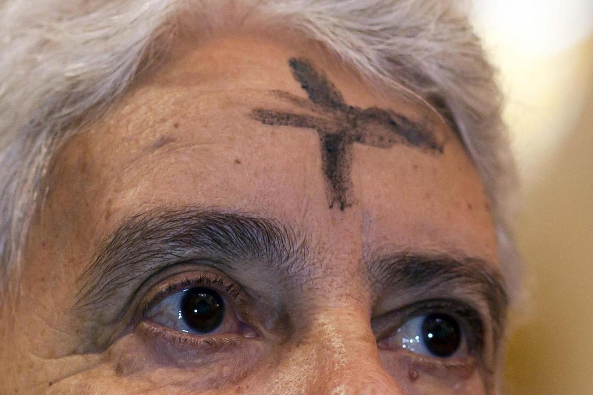 Imposición de la ceniza en la frente de una mujer.