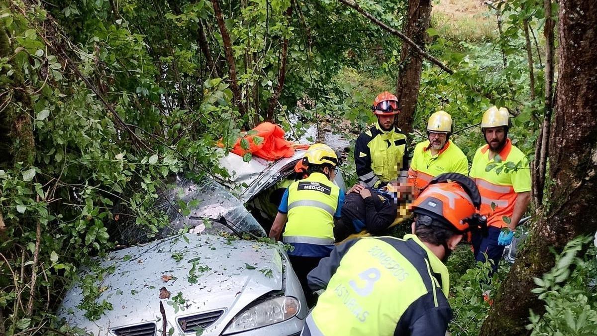 Bomberos y sanitarios junto al vehículo accidentado.