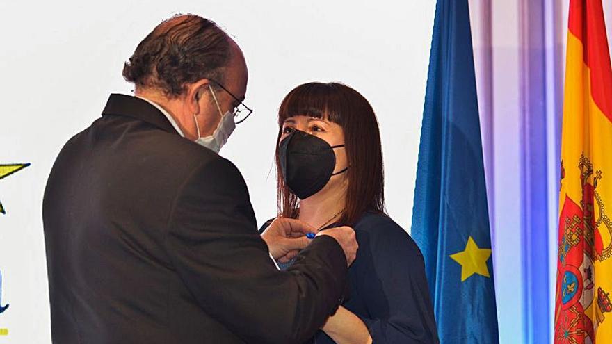José Luis Barceló, presidente de la Asociación Europea de Economía y Competitividad, colocándole la medalla a Mónica Quintana.