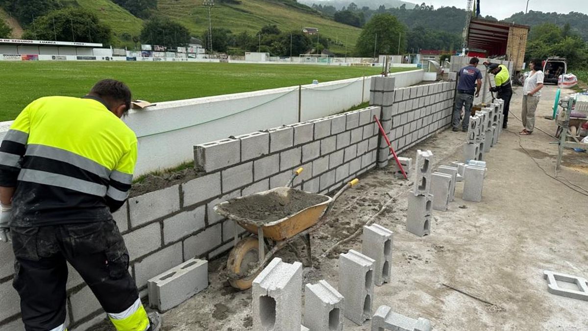 Obras en el muro exteior del campo de fútbol La Veigona de Luarca.
