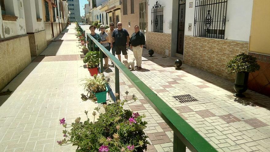 En la foto, un grupo de vecinos de la calle Anita Adamuz, próxima a la avenida del Arroyo de los Ángeles, que la han llenado de macetas de colores, al tiempo que han añadido unas tuberías a algunos bolardos para convertirlos en maceteros.