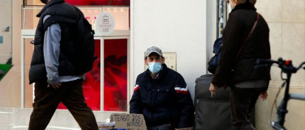 Un hombre pide limosna en una calle de València.