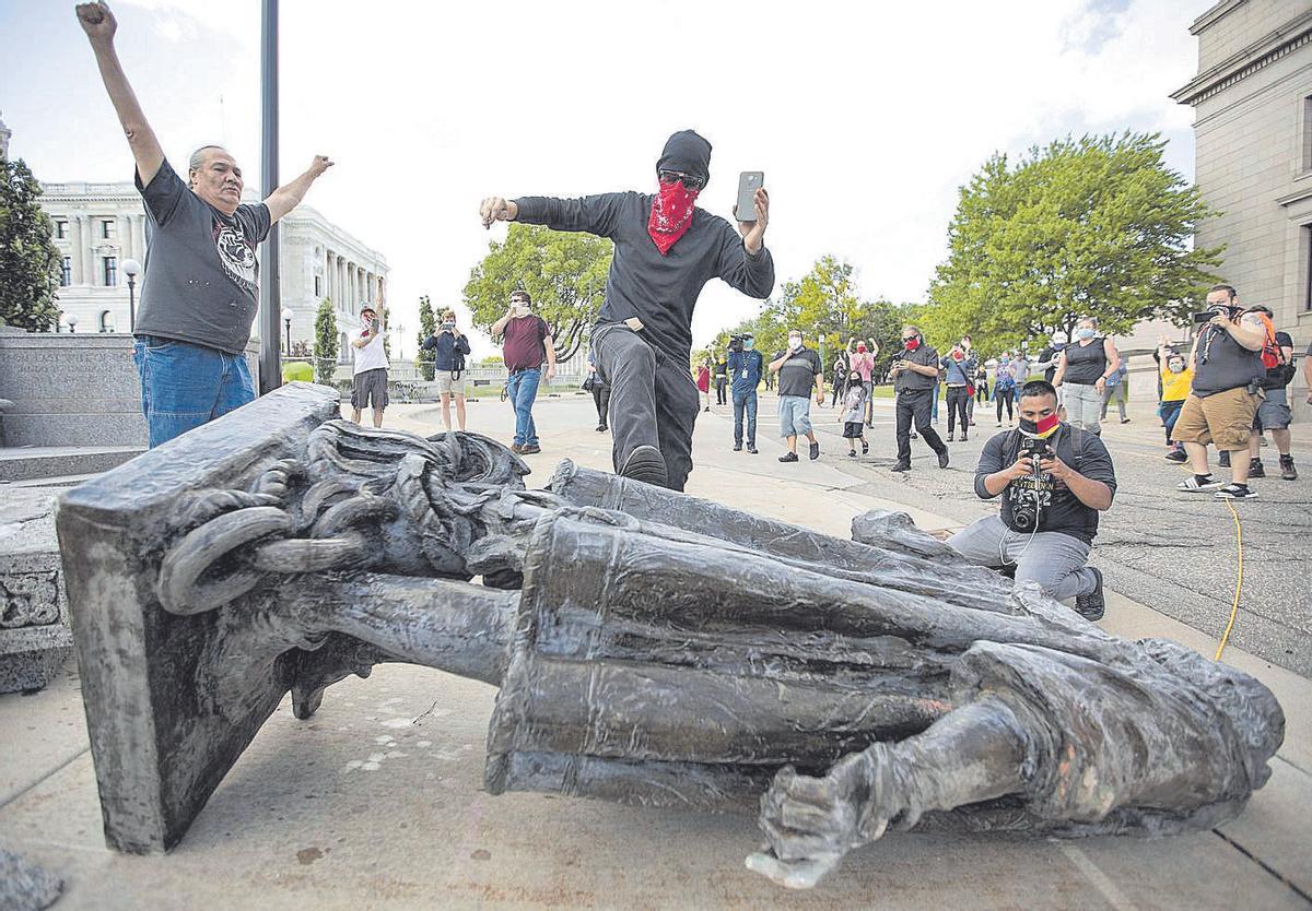 Un hombre patea la estatua de Cristóbal Colón, en Saint Paul (Minnesota), durante las protestas desatadas en 2020.