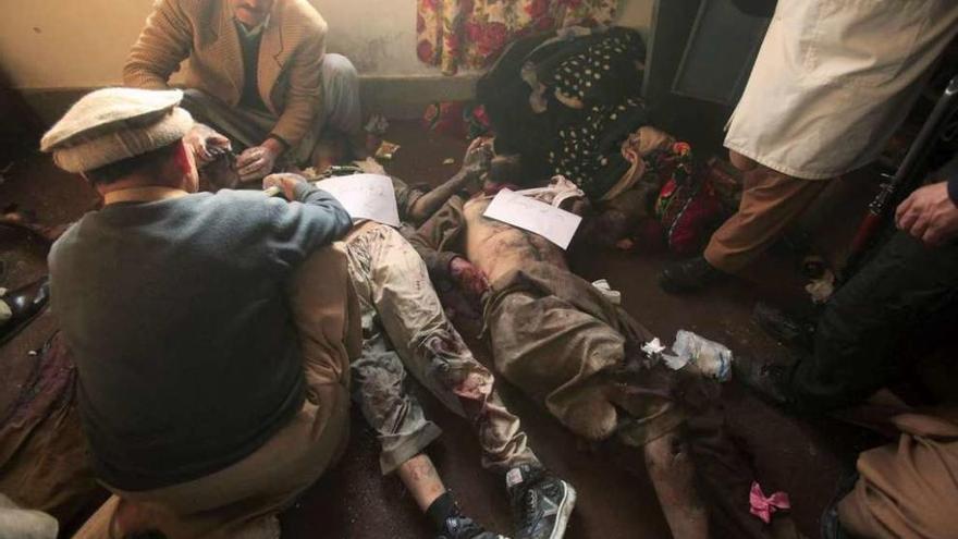 Los forenses examinan los cuerpos de dos terroristas abatidos en el dormitorio de un estudiante. // Reuters