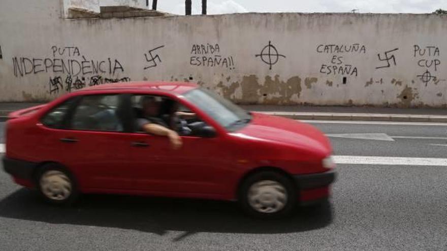 Un coche circula ante una vivienda de Alzira cubierta de mensajes y lemas nazis.