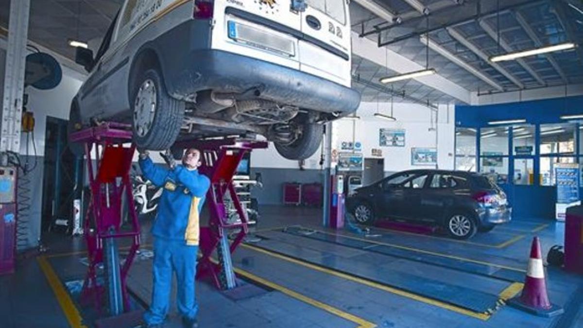 Un mecánico inspecciona unos neumáticos en un taller de Barcelona.