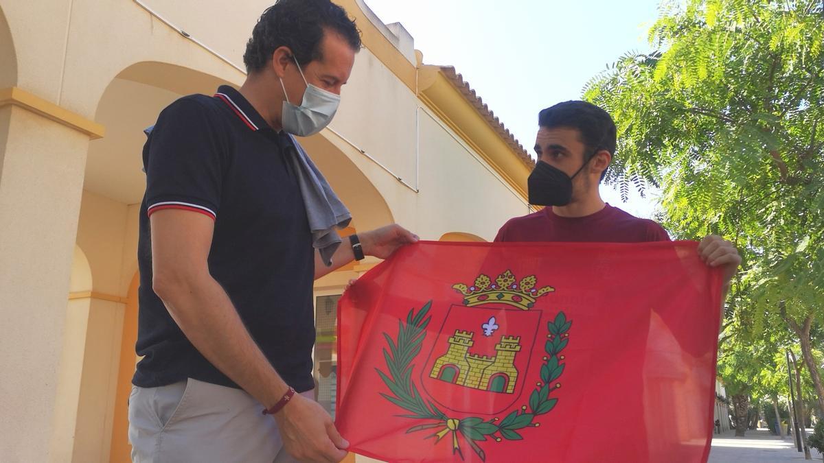 Rubén Alfaro entregándole a José Quiles la bandera de Elda para que se la lleve a Tokio.