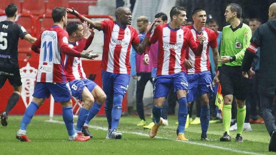 Los jugadores del Sporting protestan al asistente tras el segundo gol del Málaga.