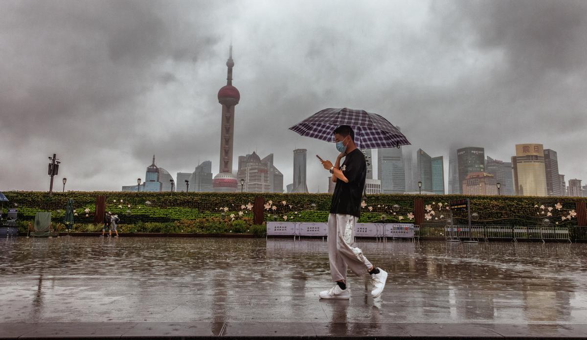 Shanghai (China), 14/09/2022.- A man walks during a rainy day as typhoon Muifa is expected to make landfall, in Shanghai, China, 14 September 2022. Chinese authorities issued a red alert in the eastern province of Zhejiang as typhoon Muifa was expected to make landfall on the east coast. Shanghai city grounded all flights from Pudong and Hongqiao airports, halted port operations, closed metro stations and limited speed for ground trains. Ningbo, Taizhou, and Zhoushan city were ordered to suspend classes for the day as the typhoon is expected to move northwest after making landfall. EFE/EPA/ALEX PLAVEVSKI