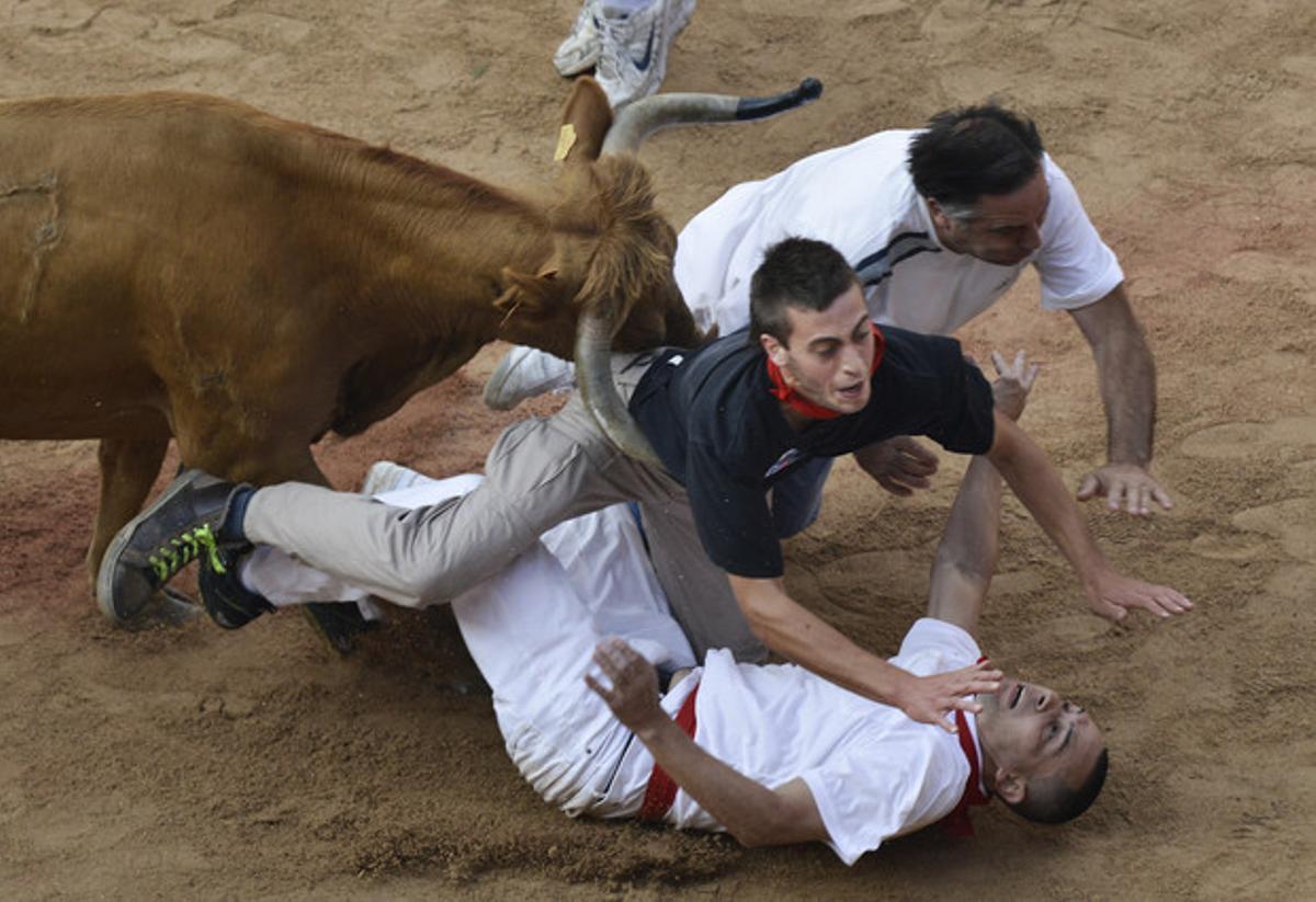 Uns quants corredors tenen un ensurt amb un dels toros dins de la plaça.