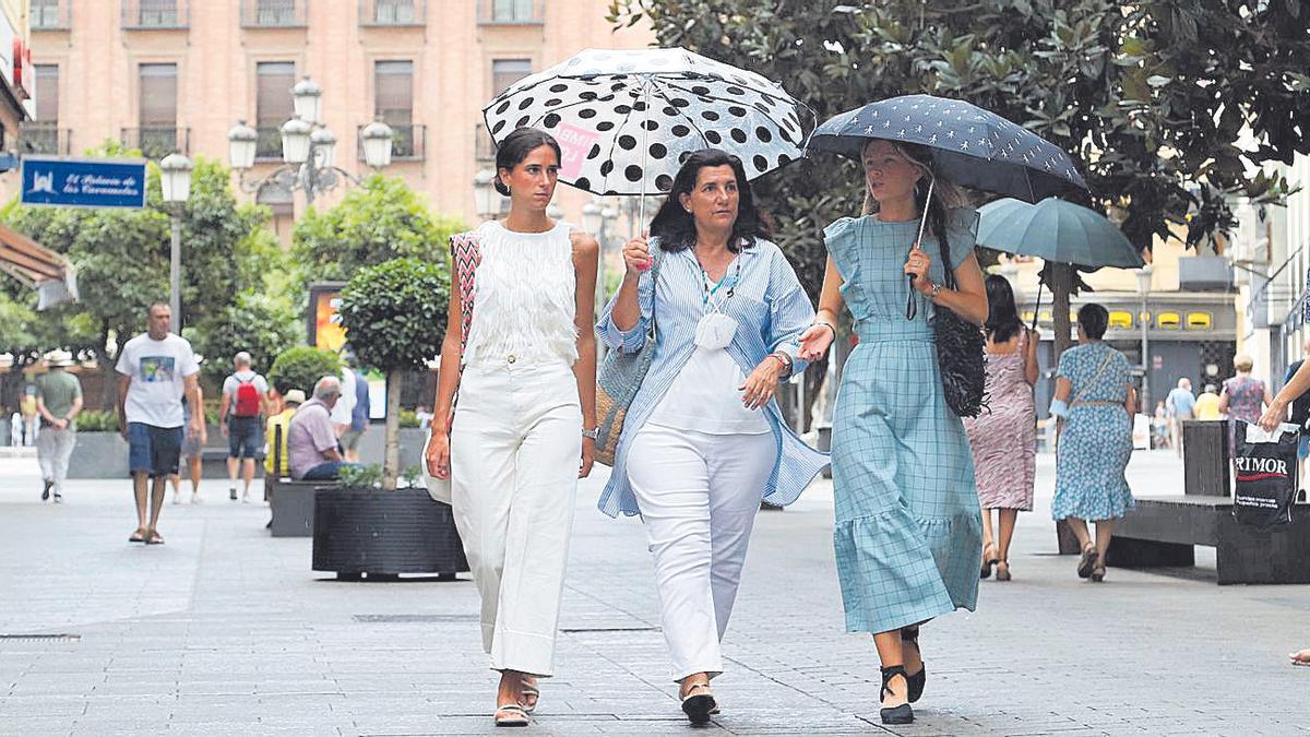 Varias mujeres sostienen sus paraguas este sábado, en Córdoba.