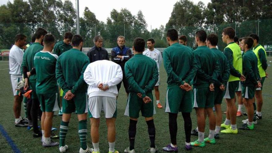 La plantilla del Coruxo rodea a Rafa Sáez durante el entrenamiento de ayer en Fragoselo. // Coruxo FC