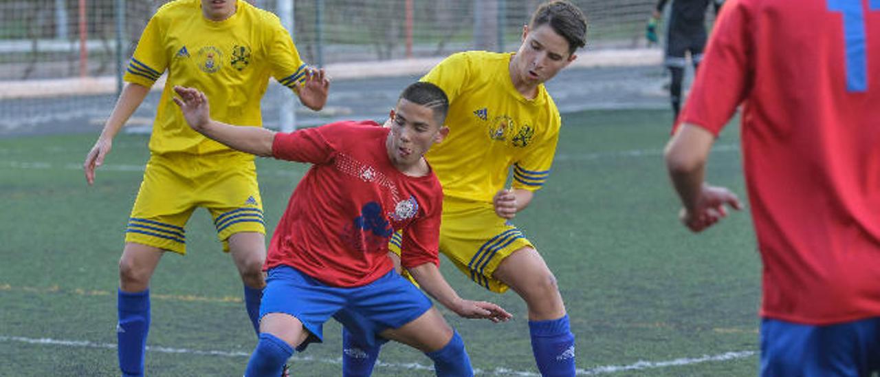 Giovanni, el hábil delantero del San Juan, trata de controlar el balón con el marcaje de dos futbolistas del Santos Las Palmas.