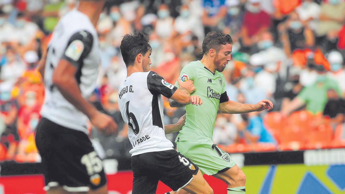 Hugo Guillamón lucha por el balón con el delantero del Ahletic de Bilbao Iker Muniain en el último partido de LaLiga disputado en Mestalla que acabó con empate a uno