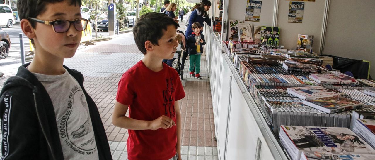 Los hermanos Martín y Adrián, de 8 y 7 años, en la Feria del Libro, este miércoles.