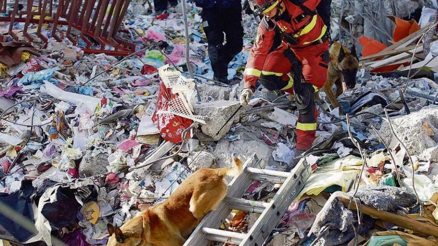 Un bombero español, en tareas de búsqueda de víctimas. En el recuadro Xosé Luis Otero.