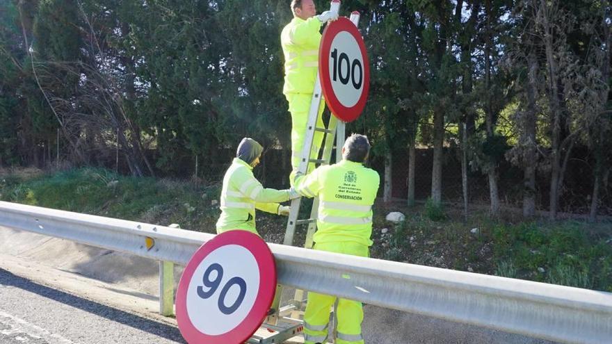 Operarios de Carreteras cambiando las señalización de velocidad máxima.