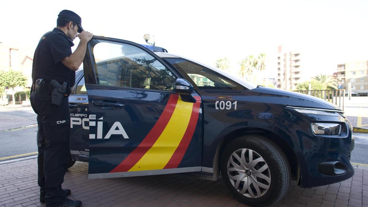 Un policía nacional, en un coche patrulla.