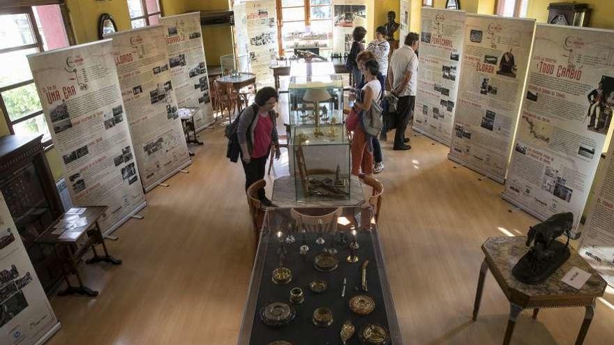 Los primeros visitantes contemplando la exposición, ayer, en el Casino de Trubia.