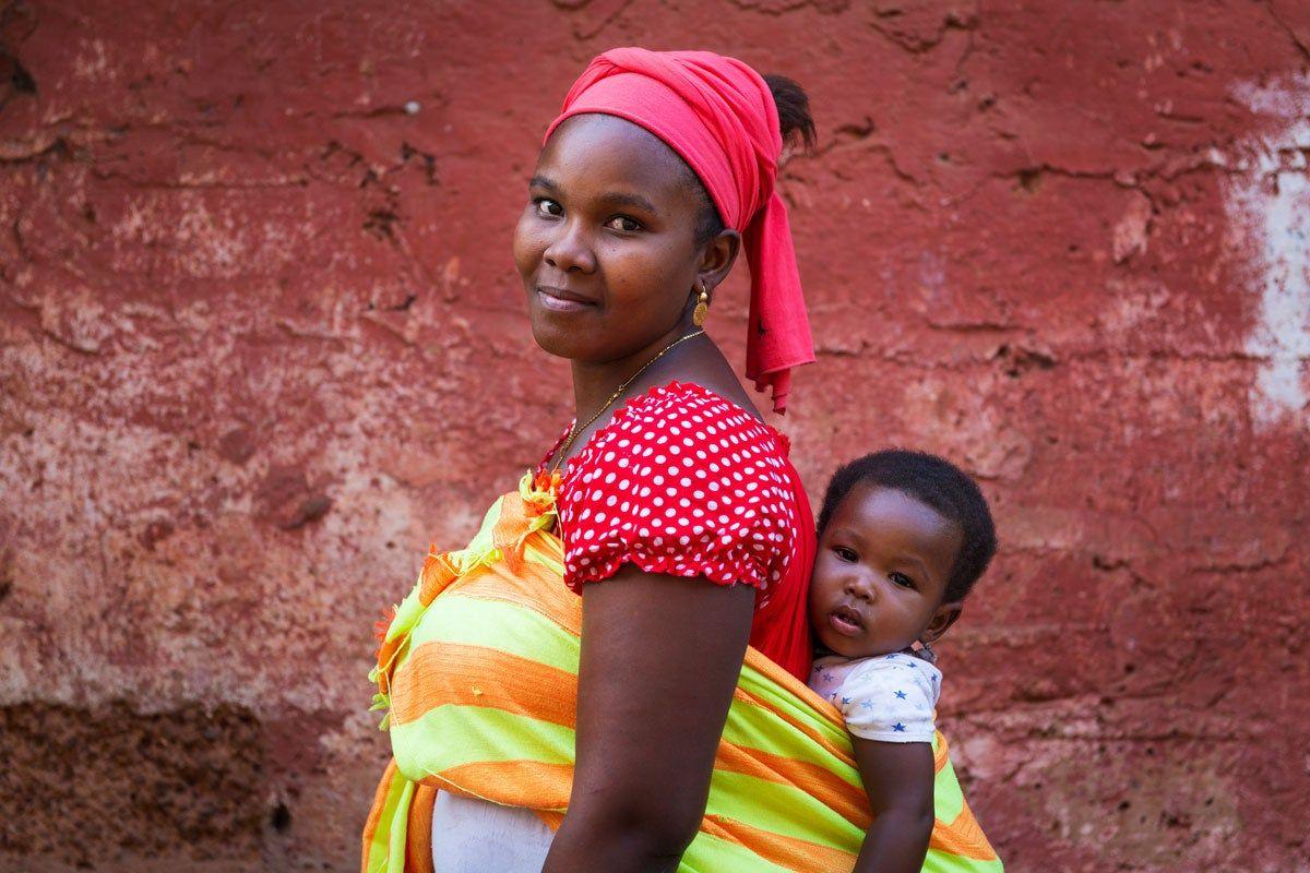 Mujer transportando a su bebé a las espaldas en Guinea Bissau