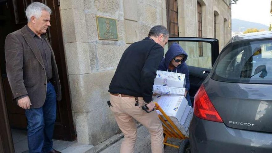 El alcalde Sobral observa como los agentes de Aduanas cargan la documentación en un coche. // G. Santos