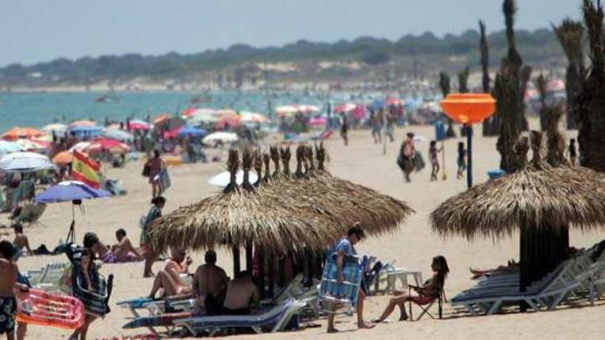 Decenas de personas tomando el sol y disfrutando en la playa de los Arenales del Sol en la jornada de ayer.