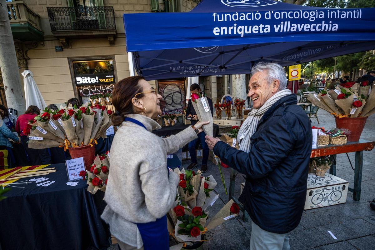 Un hombre compra una rosa de Sant Jordi, en el centro de Barcelona.
