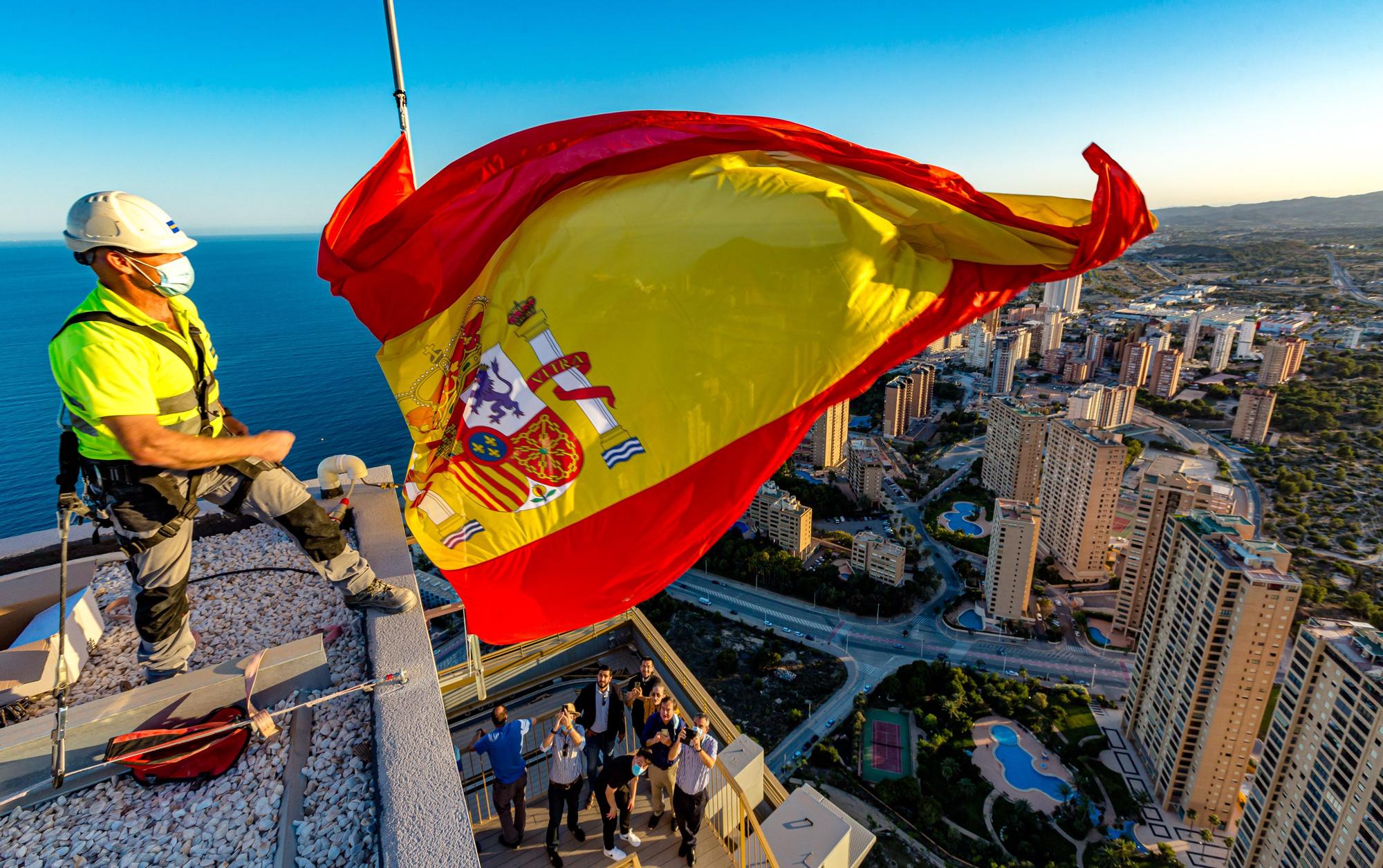 22/6/2021. El rascacielos InTempo, emblema del estallido de la burbuja inmobiliaria, escenifica la finalización de las obras colocando la bandera de España a 200 metros de altura. Los promotores prevén obtener la licencia de ocupación en julio.