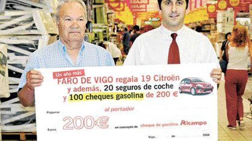 Vicente Sanromán (i) recibió el cheque gasolina de manos de Adolfo Lorenzo, en Alcampo 1. / j.a. rodríguez