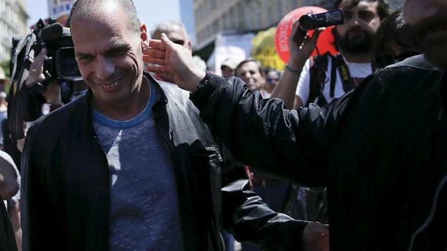 Manifestantes saludan con desenfado a Varufakis en Atenas. // Reuters