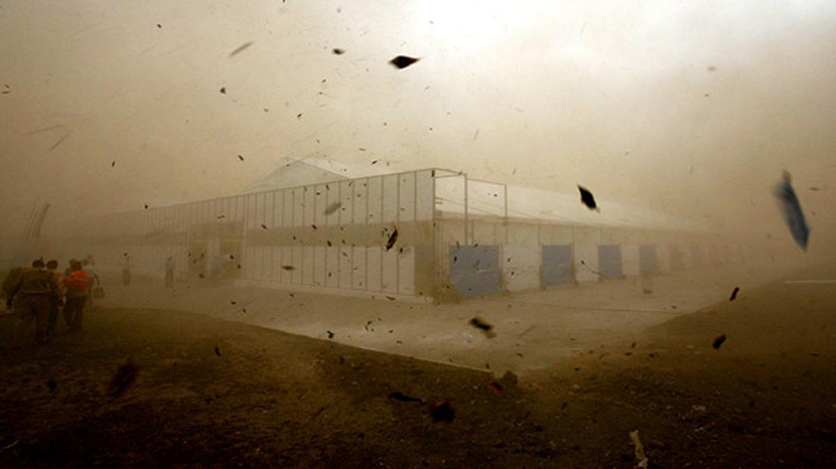 Treballadors de la planta productora del cotxe Tata Nano, acabada d’inaugurar, es refugien d’una tempesta de sorra a Sanand, a l’est de l’Índia.