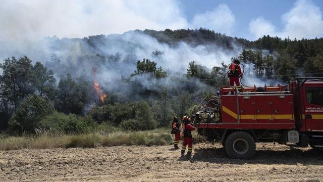 Diversos efectius de l’UME sufoquen les flames al límit de la carretera que uneix Uncastillo amb Luesia. | PABLO IBÁÑEZ.