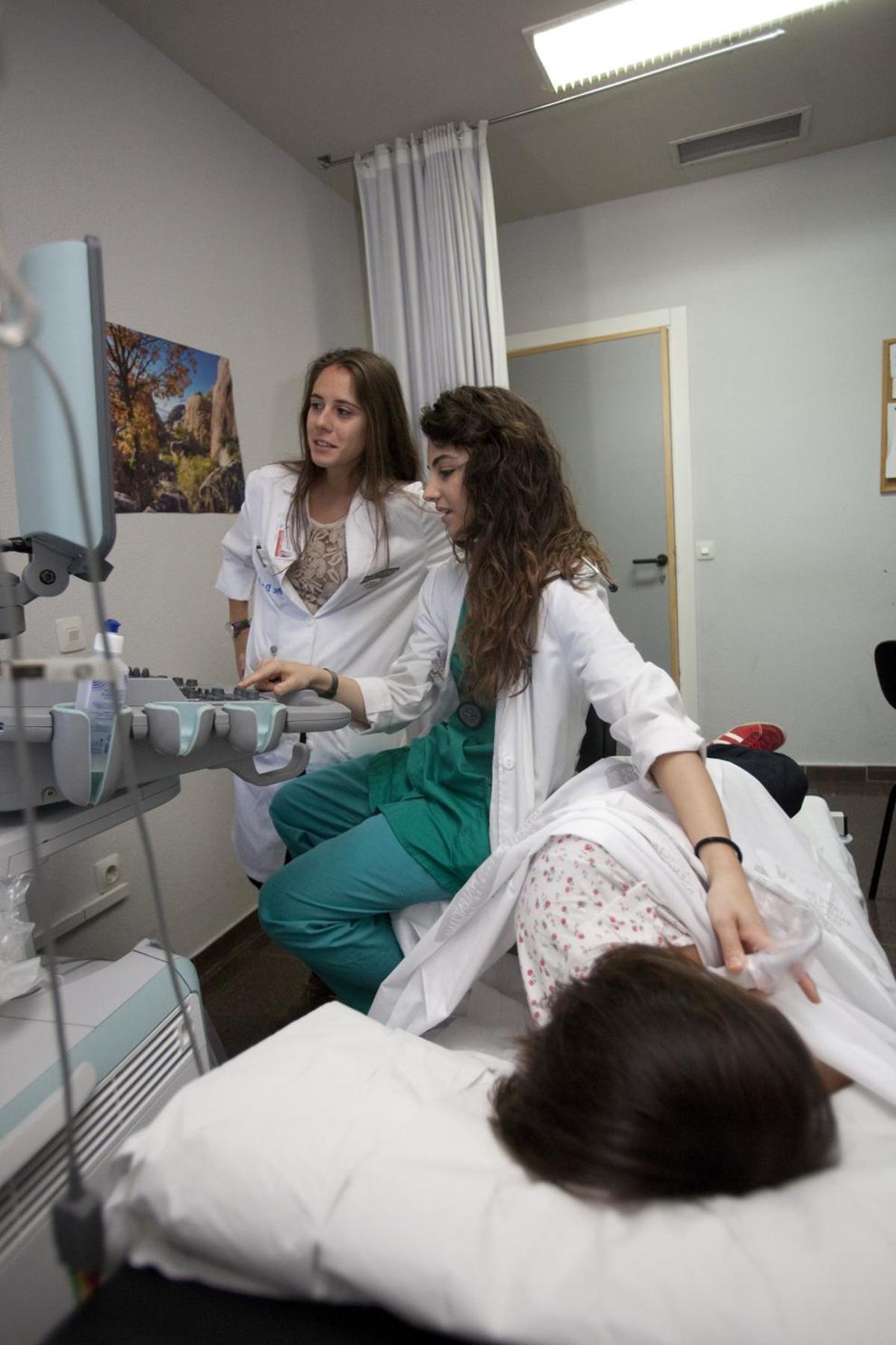 Dos profesionales sanitarias atienden a una mujer.