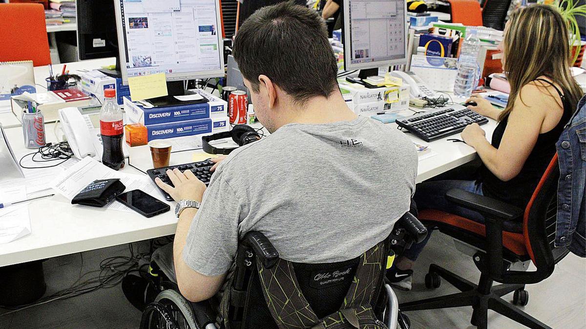 Un joven con discapacidad en su puesto de trabajo.