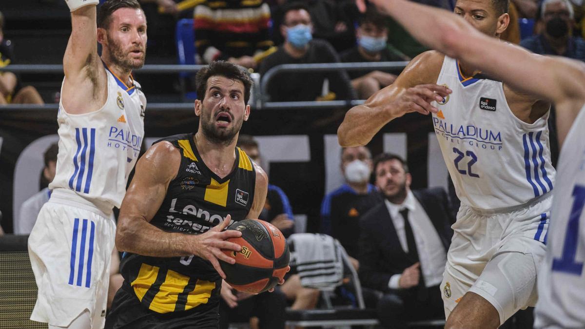 Fitipaldo penetra entre Rudy y Tavares en el último triunfo del Canarias ante el Real Madrid.