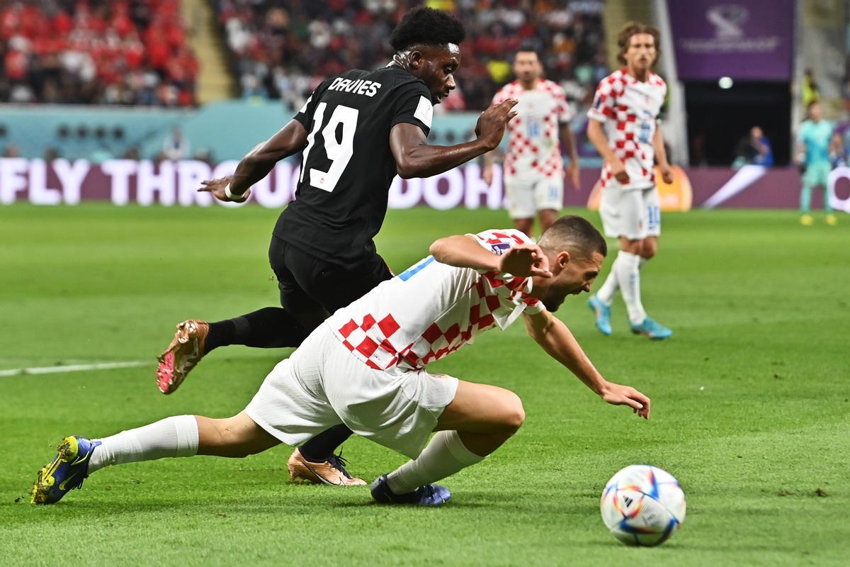 Doha (Qatar), 27/11/2022.- Mateo Kovacic of Croatia (front) in action against Alphonso Davies of Canada during the FIFA World Cup 2022 group F soccer match between Croatia and Canada at Khalifa International Stadium in Doha, Qatar, 27 November 2022. (Mundial de Fútbol, Croacia, Catar) EFE/EPA/Noushad Thekkayil