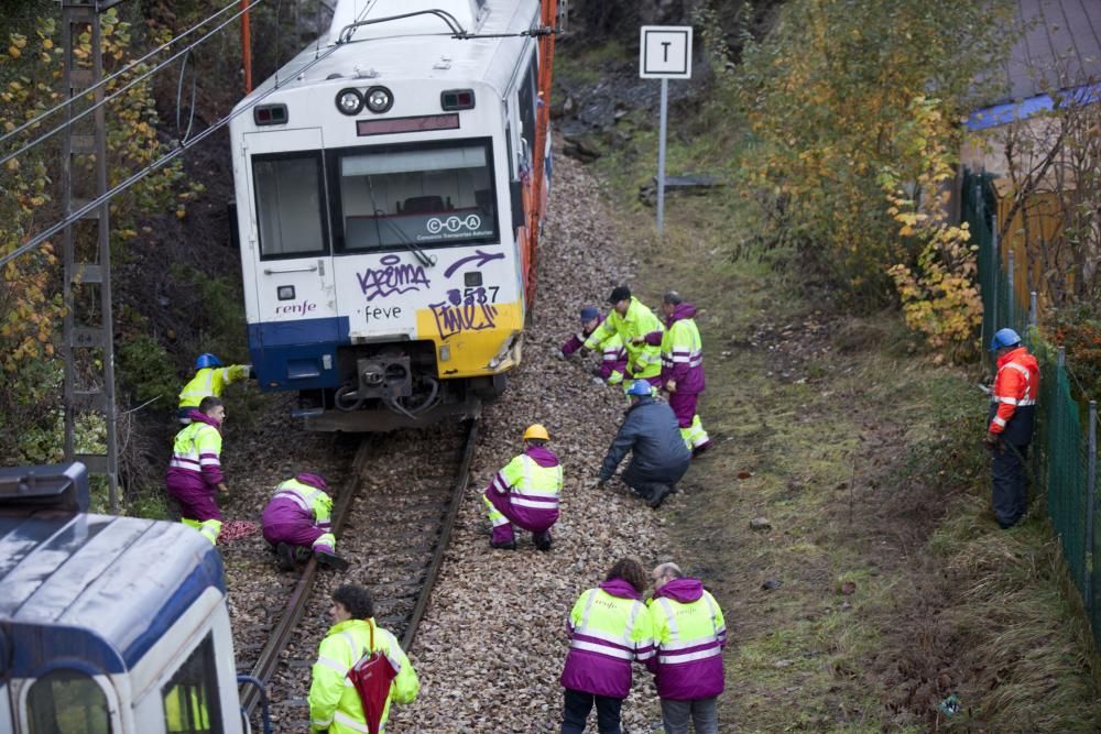 Una grúa trata de encarrilar el tren que se salió de la vía por un argayo en El Entrego