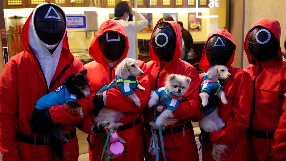 People and dogs wearing Netflix series 'Squid Game' costumes pose for photographs on the street in downtown Seoul, South Korea, October 30, 2021. REUTERS/ Heo Ran